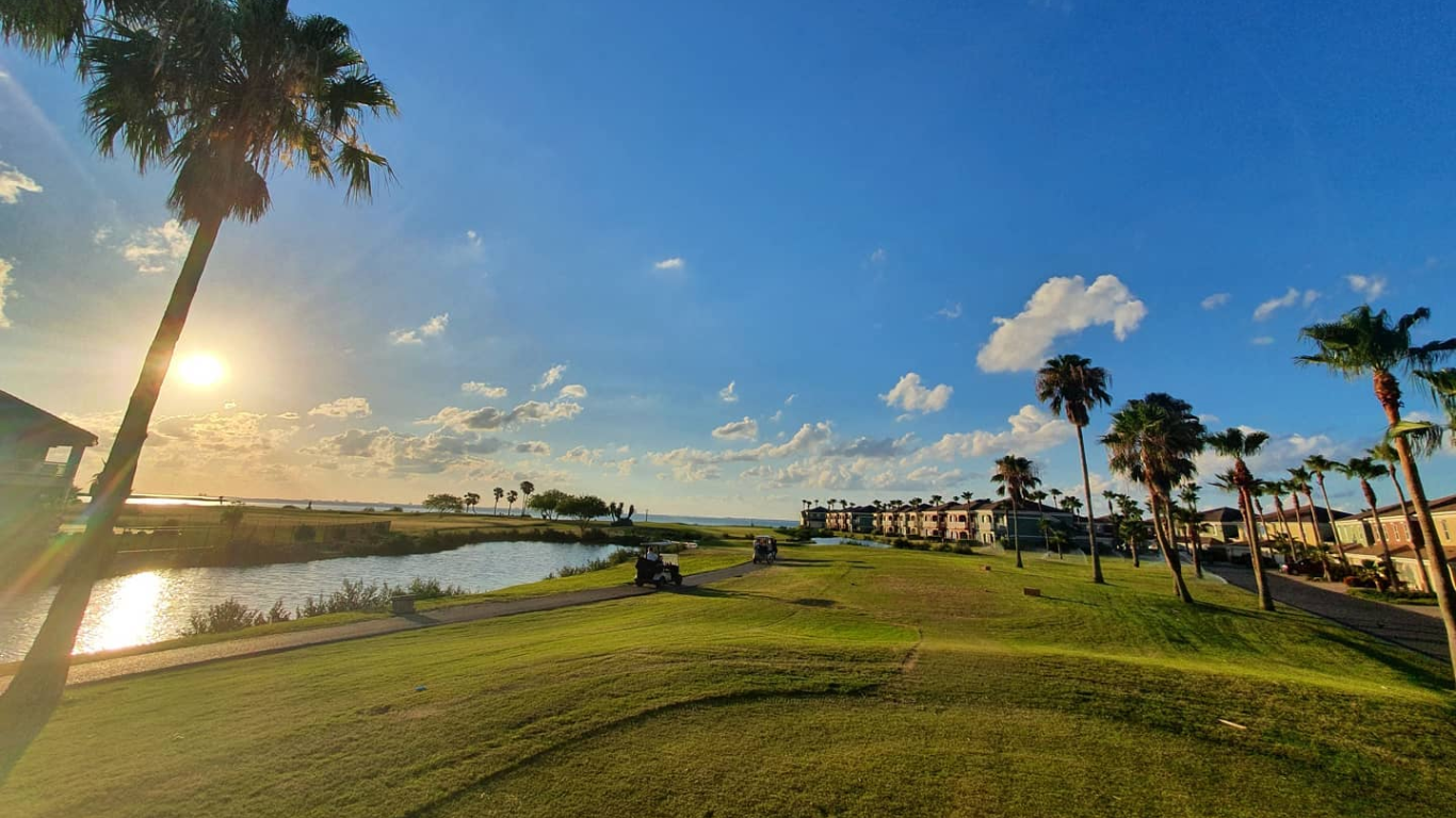 View of greens at South Padre Island Golf Club with Laguna Madre in background