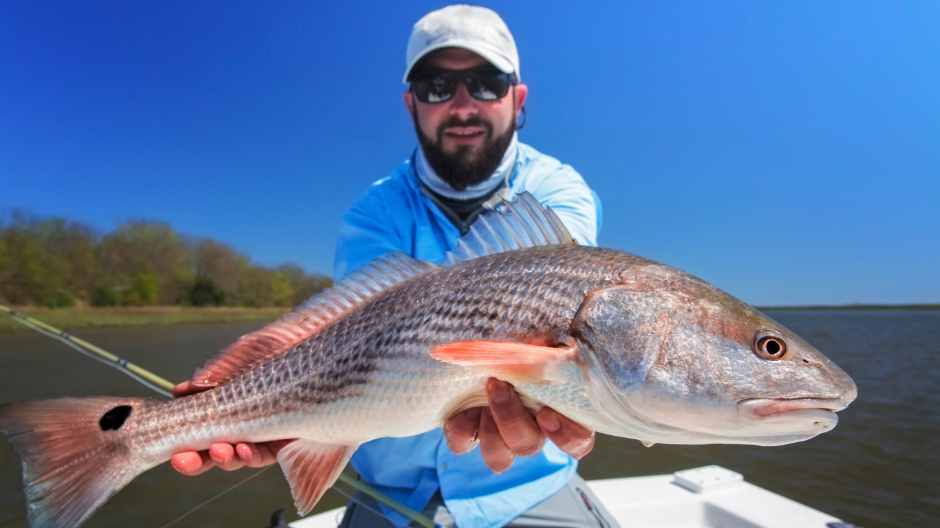 Man shows off Spotted Red Fish caught in Laguna Madre near Laguna Vista and South Padre Island Golf Club